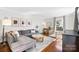 Bright living room featuring a comfortable gray sofa, wood floors, and natural light from large windows at 1148 Turnbridge Rd, Charlotte, NC 28226