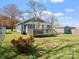 Spacious backyard with a well-maintained lawn, wooden fence, deck, and storage shed on a sunny day at 125 Ashe St, Gastonia, NC 28056