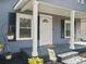 Cozy front porch featuring a white front door, porch swing, and blooming flowers at 125 Ashe St, Gastonia, NC 28056