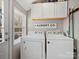 Functional laundry room with washer, dryer, storage cabinets, and natural light from the window at 125 Ashe St, Gastonia, NC 28056
