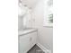 Bright bathroom featuring white cabinets, granite countertop, a window, and modern fixtures at 1308 Jay Ave, Gastonia, NC 28052