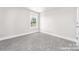 An empty bedroom featuring neutral carpeting, a window and freshly painted walls at 1308 Jay Ave, Gastonia, NC 28052