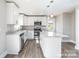 Modern kitchen with stainless steel appliances, white cabinets, gray granite counters and an island with pendant lights at 1308 Jay Ave, Gastonia, NC 28052