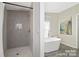 Modern bathroom featuring a stylish tiled shower and a luxurious soaking tub, creating a spa-like retreat at 140 Sanford Ln, Badin Lake, NC 28127