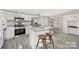 Modern kitchen features stainless steel appliances, granite countertops, and a center island with bar stool seating at 140 Sanford Ln, Badin Lake, NC 28127