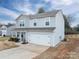 Side view of a well-maintained two-story home featuring a two-car garage and blue siding at 1587 Berkshire Dr, Newton, NC 28658