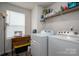 Functional laundry room with a window, washer, dryer, sewing machine and shelving at 1587 Berkshire Dr, Newton, NC 28658