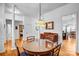 A dining room set with a glass table on hardwood flooring, well lit by a chandelier at 162 Pecan Hills Dr, Mooresville, NC 28115