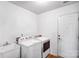 Laundry room with washer, dryer, ceramic tile floors, sink, and a white door at 162 Pecan Hills Dr, Mooresville, NC 28115