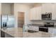 Modern kitchen featuring stainless steel appliances, granite countertops, and white cabinets at 164 Wembury Ln, Troutman, NC 28166