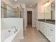 Bathroom featuring a soaking tub, glass shower, and double vanity at 16725 Cozy Cove Rd, Charlotte, NC 28278