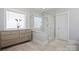 Bright bathroom featuring a glass-enclosed shower and natural wood vanity at 190 Hidden Meadows Dr, Mooresville, NC 28117