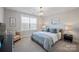 Serene bedroom featuring a patterned quilt, soft lighting, and a large window for ample sunlight at 190 Hidden Meadows Dr, Mooresville, NC 28117