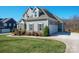 Beautiful home featuring well-manicured lawn, vertical siding, a three-car garage, and a charming landscape at 190 Hidden Meadows Dr, Mooresville, NC 28117