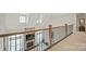 Hallway with open railing overlooking the living room, fireplace and large windows at 190 Hidden Meadows Dr, Mooresville, NC 28117