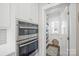 Modern kitchen features double ovens and a pantry with shelving for storage and organization at 190 Hidden Meadows Dr, Mooresville, NC 28117