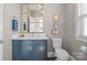 Stylish powder room features a blue vanity with white countertop and a decorative gold trimmed mirror at 190 Hidden Meadows Dr, Mooresville, NC 28117