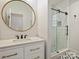 Bright bathroom features a glass shower with patterned tile, a round mirror, and a white vanity at 2004 Lombardy Cir, Charlotte, NC 28203