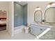 Bright bathroom features a double vanity, a bathtub with blue tiled walls, and tile flooring at 2004 Lombardy Cir, Charlotte, NC 28203