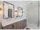 Bright bathroom features a double vanity with rectangular mirrors, sconces, and a glass shower with tile walls at 2004 Lombardy Cir, Charlotte, NC 28203
