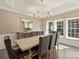 Elegant dining room featuring a long wood table, tufted chairs, chandelier and windows at 2004 Lombardy Cir, Charlotte, NC 28203