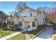 Angled view of a charming white two-story home with brick walkway, stone wall and manicured front yard at 2004 Lombardy Cir, Charlotte, NC 28203