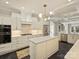 Bright kitchen featuring white cabinets, stainless steel appliances, and large center island at 2004 Lombardy Cir, Charlotte, NC 28203