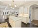 Open-concept kitchen with an island, white cabinets and stainless steel appliances, with view to living spaces at 2004 Lombardy Cir, Charlotte, NC 28203