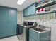 Modern laundry room with ample storage, stainless steel washer/dryer, and stylish wallpaper at 2004 Lombardy Cir, Charlotte, NC 28203