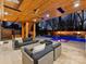 A covered outdoor living space with a stone patio, outdoor seating and a luxurious pool featuring fire bowls at 2004 Lombardy Cir, Charlotte, NC 28203