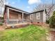 Spacious backyard featuring a covered porch, green lawn, and mature trees, creating a private oasis at 2009 Charlotte Dr, Charlotte, NC 28203