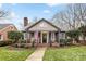 Charming home featuring a quaint front porch with rocking chairs and an American flag at 2009 Charlotte Dr, Charlotte, NC 28203