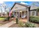 Inviting front porch with rocking chairs, porch swing, brick floor, and stylish columns at 2009 Charlotte Dr, Charlotte, NC 28203