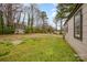 Large, grassy backyard with mature trees and an additional structure in the distance at 202 Hovis Rd, Stanley, NC 28164