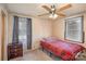 Bedroom features a red plaid bedspread, ceiling fan, and neutral walls, perfect for relaxation at 202 Hovis Rd, Stanley, NC 28164