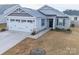 Charming single-story home with stone accents, a two-car garage, and a well-manicured lawn at 239 Damask Dr, Lancaster, SC 29720