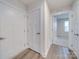 Hallway featuring hardwood floors, neutral walls, and white doors leading to multiple rooms, creating a seamless flow at 239 Damask Dr, Lancaster, SC 29720