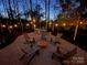 An inviting backyard patio with comfortable seating, a fire pit, and string lights for memorable outdoor gatherings at 341 Beckwick Ln, Concord, NC 28025