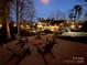 Backyard patio featuring gravel, chairs, fire pit, and view of house, landscaping, and parking area at 341 Beckwick Ln, Concord, NC 28025