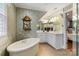Elegant bathroom with a freestanding tub, custom cabinetry, and stylish decor at 341 Beckwick Ln, Concord, NC 28025