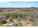 Scenic aerial view showcases a neighborhood nestled amidst lush forest and rolling hills in the distance at 345 Briar Creek Rd, Gastonia, NC 28056