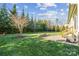 A landscaped backyard with a stone patio and mature trees create a peaceful outdoor space at 401 Pecan Ridge Ct, Weddington, NC 28104