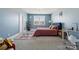 A spacious bedroom features light blue walls, large window, and charming chandelier at 401 Pecan Ridge Ct, Weddington, NC 28104