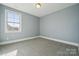 A bright bedroom with neutral paint and carpet has one large window at 401 Pecan Ridge Ct, Weddington, NC 28104