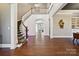 Open foyer with hardwood floors, a staircase, and an arched entryway to adjoining rooms at 401 Pecan Ridge Ct, Weddington, NC 28104