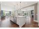 Open kitchen featuring a large island with a stainless dishwasher and hardwood floors at 401 Pecan Ridge Ct, Weddington, NC 28104