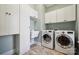 Well-organized laundry room featuring washer, dryer, sink, and built-in cabinets at 401 Pecan Ridge Ct, Weddington, NC 28104