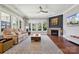 Cozy living room with a fireplace, large windows, neutral decor, and hardwood floors at 401 Pecan Ridge Ct, Weddington, NC 28104