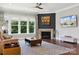 Living room with a fireplace, large windows, neutral decor, hardwood floors and mounted television at 401 Pecan Ridge Ct, Weddington, NC 28104