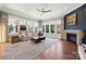Bright living room featuring a fireplace, large windows, neutral decor, and hardwood floors at 401 Pecan Ridge Ct, Weddington, NC 28104
